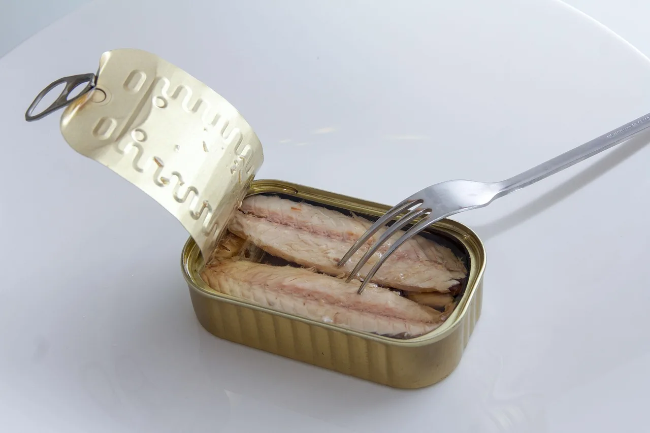 Sgombro in scatola su un tavolo, con verdure fresche e informazioni nutrizionali in evidenza.